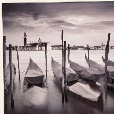 many boats that are tied to poles in the water