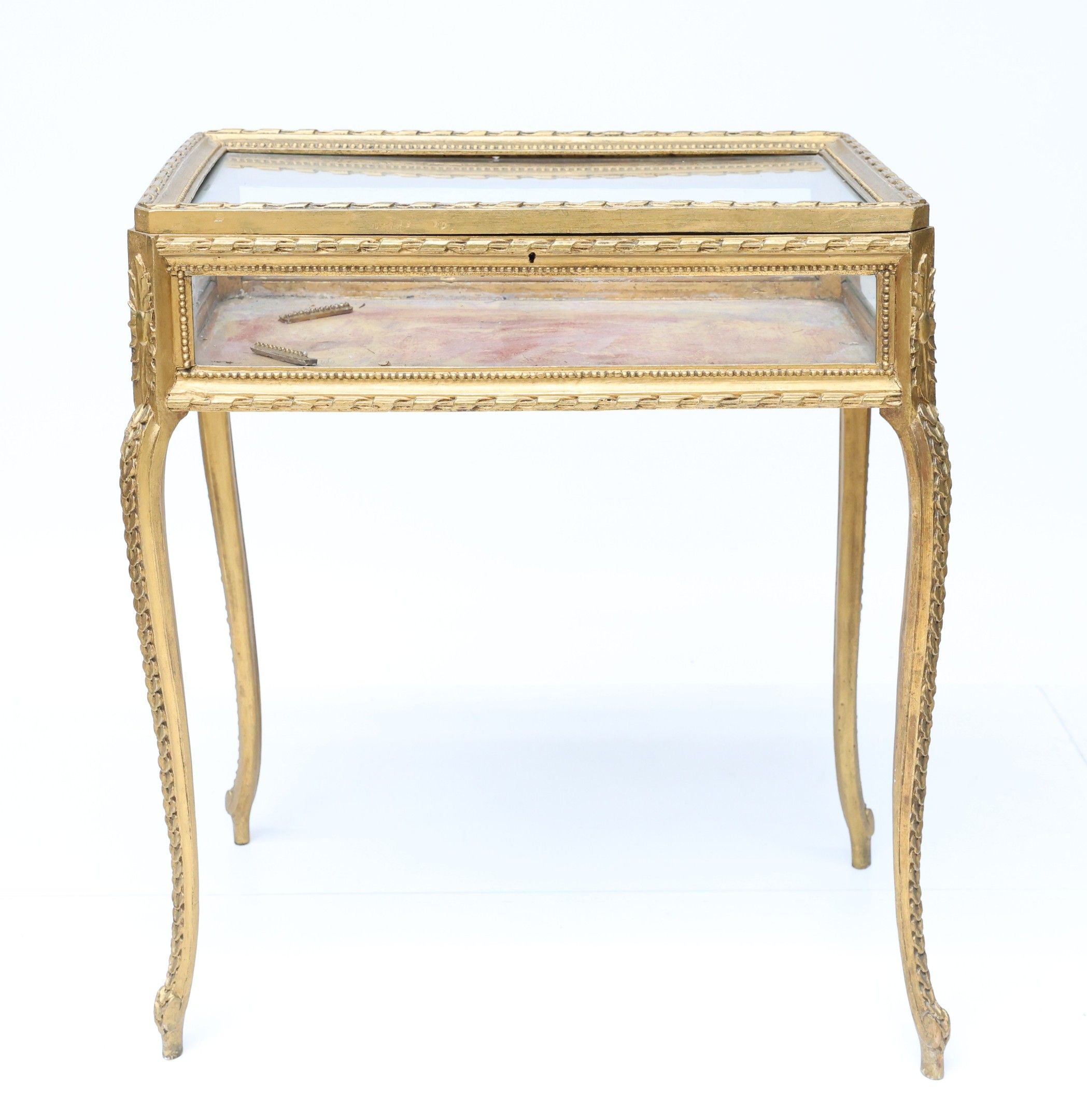 Vitrine en bois sculpté et doré de forme rectangulaire repos…