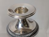 a silver candle holder sitting on a white table