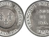 a close up of a silver coin with a design on it