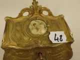 a gold box with a clock on top of it