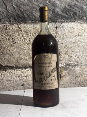 une bouteille d'alcool posée sur une table près d'un mur de briques