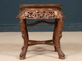 a small wooden table with carvings on it