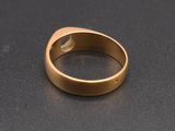 a close up of a gold ring on a black surface