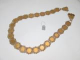 collier avec une pièce d'or et un fermoir, sur un fond blanc