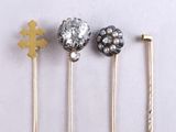three gold and silver hair pins sitting next to each other on a white surface