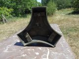 un gros objet métallique posé sur une dalle de béton