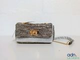pochette en tweed gris et doré avec une bandoulière en chaîne dorée
