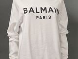 un sweat-shirt blanc sur lequel est imprimé le mot « Balmain Paris »