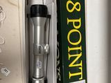 a silver and black coffee maker in a box