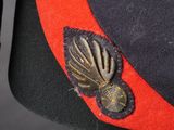 uniform of a man in a military uniform with a red band and a black hat with a gold eagle on it