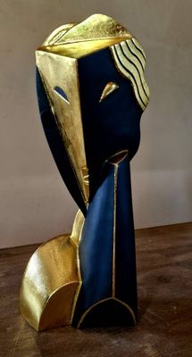 a blue and gold sculpture of a man ' s head on a wooden table