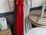 a red robe hanging on the wall next to a table and chairs