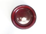 a red bowl on a white surface with a white background