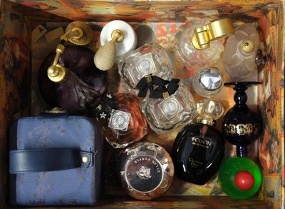 a wooden box filled with perfume bottles and a purse