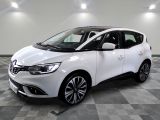 une voiture blanche est garée dans une pièce au sol à carreaux