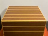 une boîte en bois posée sur une table orange