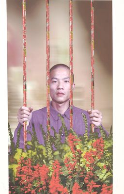 a picture of a man behind bars with flowers in front of him