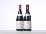two bottles of red wine sitting next to each other on a table