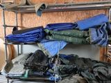 de nombreux sacs de vêtements posés sur un portant métallique dans une pièce
