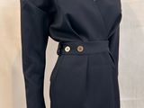 the dress is black and has a gold buckle on the waist
