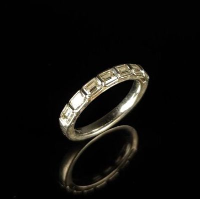 gros plan d'une bague en argent sur une surface noire
