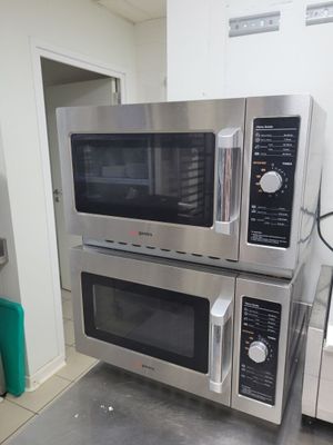 deux micro-ondes empilés l'un sur l'autre dans une cuisine