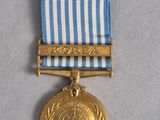 an image of a gold medal with a blue and white ribbon