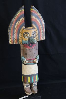 a close up of a wooden statue on a black surface