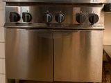 une cuisinière en acier inoxydable dans une cuisine au sol carrelé