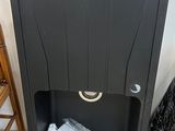a black trash can sitting on the floor next to a chair