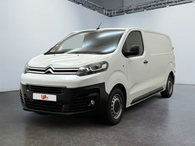 La camionnette blanche est garée dans une grande pièce d'un immeuble.