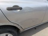 a car that has been dented and is parked in a parking lot