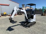 a small excavating machine parked in front of a building