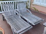 two chaise loungers on the patio next to a potted plant