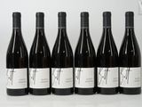 six bottles of wine are lined up in a row on a table