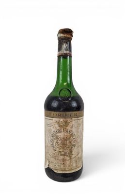 une vieille bouteille de vin posée sur une surface blanche