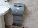 a bathroom with a toilet, sink and a paper towel dispenser