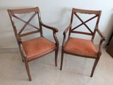 deux chaises en bois avec des coussins rembourrés orange dans une pièce