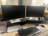 a desk with two computer monitors and a keyboard on it