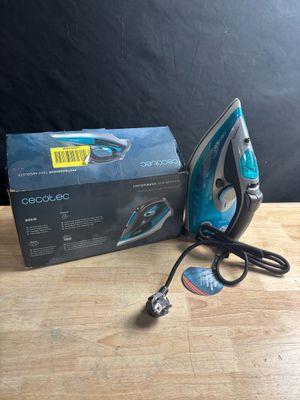 an electric iron sitting on top of a wooden table next to a box