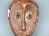 une image représentant un masque en bois sur fond gris