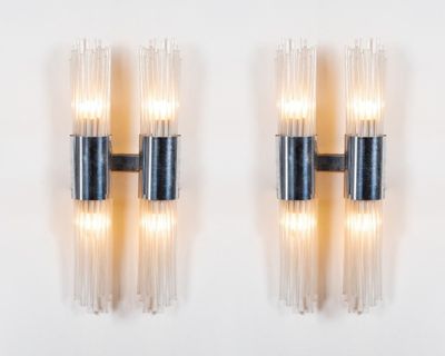 two black and clear glass sconces mounted on a white wall