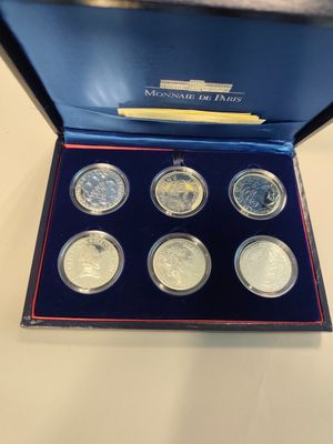 a set of six silver coins in a blue box