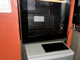 an image of a small kitchen with a refrigerator and coffee maker