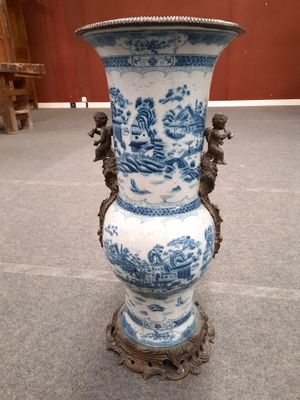 un vase bleu et blanc posé par terre