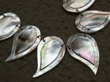 quatre pendentifs en forme de feuille d'argent sur fond noir