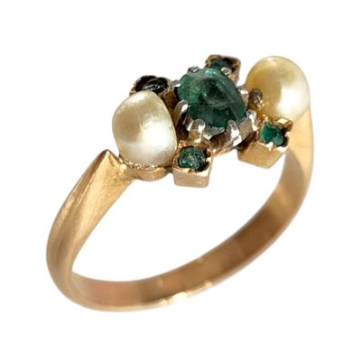 une image montrant un gros plan d'une bague ornée de perles et d'émeraudes