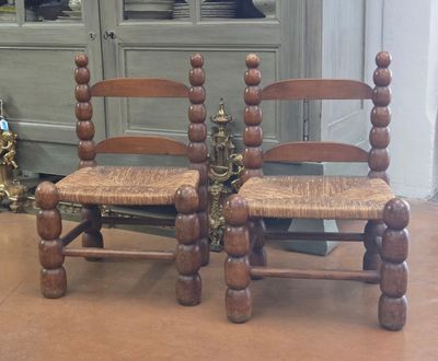 two wooden chairs sitting next to each other on the floor