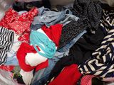 a pile of clothes that is sitting on a bed